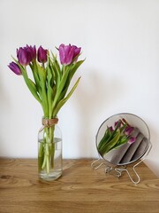 Fioletowe tulipany w wazonie na drewnianym biurku © Wiktoria