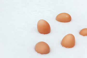 Chicken eggs in the snow. A modern composition about village life. Easter theme