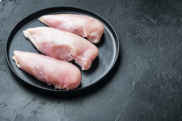 Chicken uncooked meat, on black background  with copy space