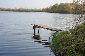Bridge over the water on the shore of the autumn lake