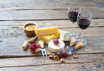 Romantic supper with a fresh cheese and red wine on the rustic wooden table.