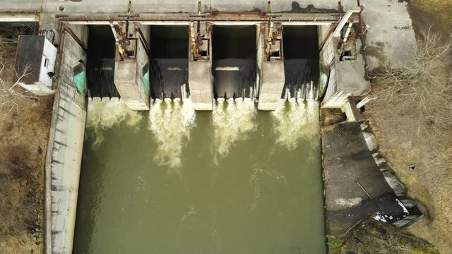 Drone camera slowly landing ,in front of  a small dam over Olt river at springtime in Transylvania, Romania.