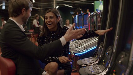 Young couple playing slot machine