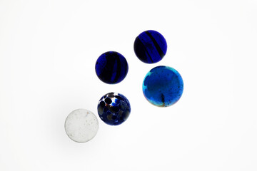 Biglie in vetro colorato, isolate su fondo bianco; piccola collezione multicolore