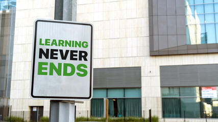 Learning never ends sign in a downtown city setting