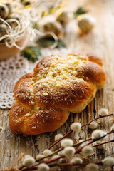 Traditional yeast challah with crumble on a wooden table, close up view.