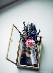 The groom's bud is in a glass box. dry flowers in the casket. Lavender for the groom at the wedding. Wedding decoration, an attribute of a man's suit