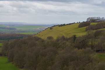 Fototapeta na wymiar scenic view south west over Oare and across the Pewsey Vale valley with green pastures and a moody raincloud sky