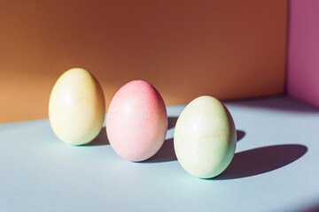 Trend pastel colorful Easter eggs on orange and blue background Copy space for text