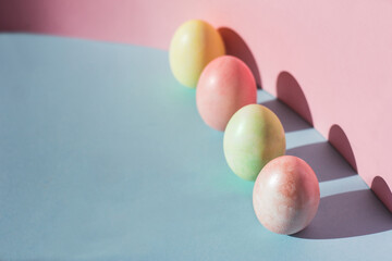 Trend pastel colorful Easter eggs on pink and blue background Copy space for text