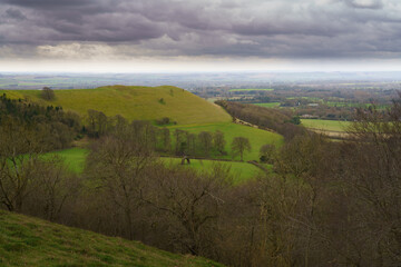Obraz premium scenic Southerly view over Oare and across the Pewsey Vale valley with green pastures and a moody raincloud sky
