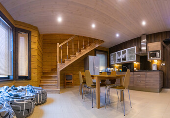Home interior. Interior of a private house made of wood. Concept - interior design of a private house. Combined kitchen and dining room in  house. The beanbag chairs are by the window.