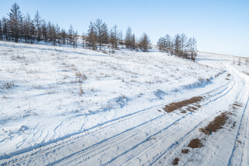 Winter country road on the slope of the hill