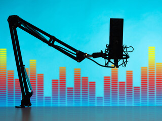 Microphone as a symbol of broadcasting. Silhouette of a microphone on an equalizer background....