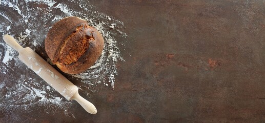 Homemade sourdough bread with, rolling pin and spilled flour