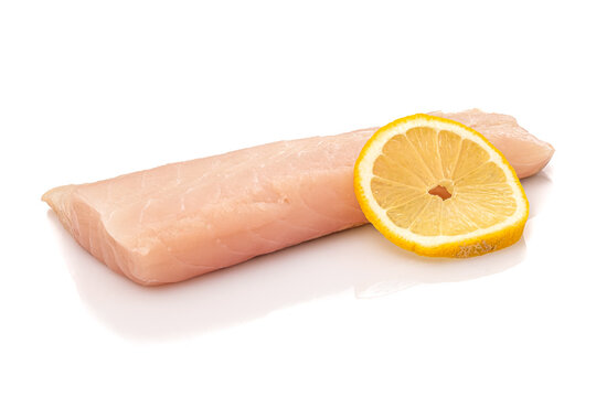 Raw pollack fish fillet with slice of lemon