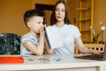 A mother and her child are engaged in distance learning at home in front of the computer. Stay at home, training