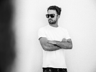 Portrait of handsome confident  stylish hipster lambersexual model.Man dressed in white T-shirt....