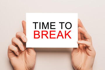 Female hands hold card paper with text TIME TO BREAK on a yellow background. Business and finance concept