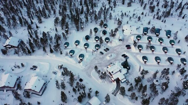 Aerial view around aurora igloos, sunny evening, in Lapland - circling, drone shot