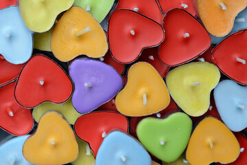 A random selection of coloured heart shaped candles, with one 'odd one out' coloured purple.