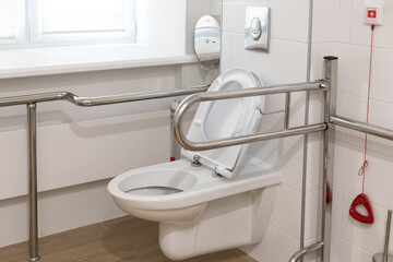 Equipped toilet room for the elderly, invalides and low-mobility people in a public place. SOS staff call handlers