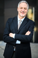 Mature business man portrait outdoor with folded arms