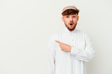 Young Arab man wearing the typical arabic costume isolated on white background pointing to the side