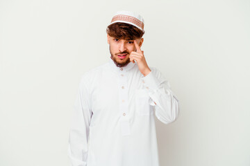 Young Arab man wearing the typical arabic costume isolated on white background showing a disappointment gesture with forefinger.