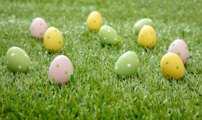 Happy Easter. Pastel colored eggs on green grass, close up view