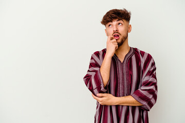 Young Moroccan man isolated on white background relaxed thinking about something looking at a copy space.