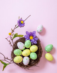 Happy Easter. pastel color eggs in a nest on pink background