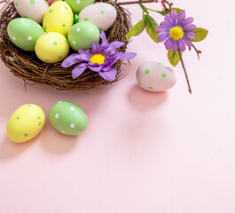Happy Easter. pastel color eggs in a nest on pink background