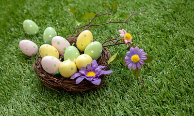 Happy Easter. Colorful eggs in a nest on green grass, close up view