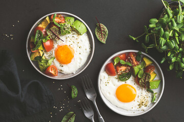 Fototapeta na wymiar Sunny side up egg breakfast with avocado salad on plate, top view. Healthy breakfast food