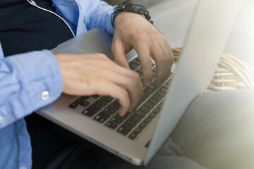 Close-up of a guy's hands typing on a laptop