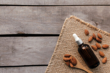 Almond essential oil in glass bottle with spoon. Cosmetic concept