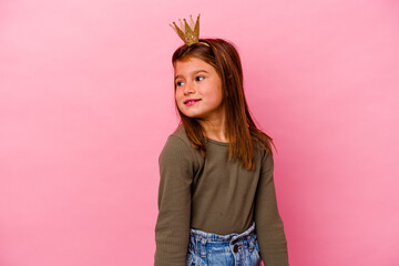Little princess girl with crown isolated on pink background dreaming of achieving goals and purposes