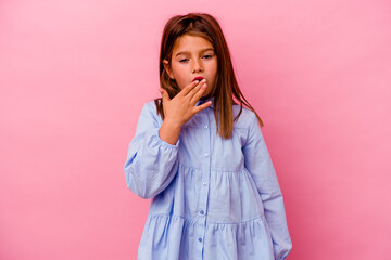 Little caucasian girl isolated on pink background yawning showing a tired gesture covering mouth with hand.