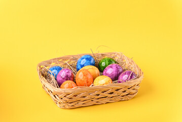 Colorful easter eggs in the basket on the blue background.