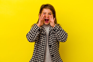 Little caucasian girl isolated on yellow background shouting excited to front.