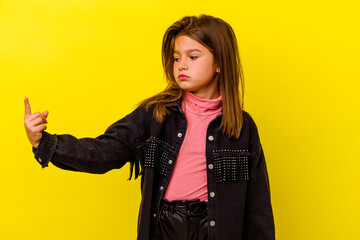 Little caucasian girl isolated on yellow background pointing with finger at you as if inviting come...