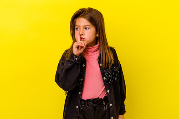 Little caucasian girl isolated on yellow background keeping a secret or asking for silence.