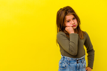 Little caucasian girl isolated on yellow background who feels sad and pensive, looking at copy...