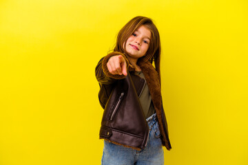 Little caucasian girl isolated on yellow background cheerful smiles pointing to front.