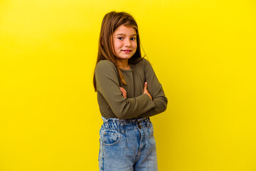 Little caucasian girl isolated on yellow background laughing and having fun.