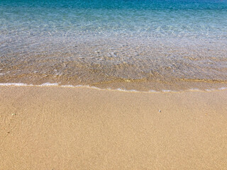 Fototapeta na wymiar smooth waves of the sea on a sandy beach in summer