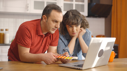 Young couple choosing colors from the color guide palette. The newly married couple choosing the...