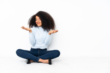 Young african american woman sitting on the floor making doubts gesture