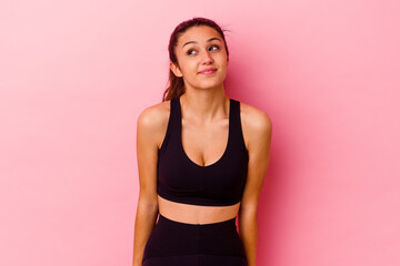 Young sport Indian woman isolated on pink background dreaming of achieving goals and purposes